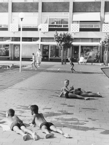 603455 Afbeelding van enkele zonnende jongens op de betontegels van de speelplaats op het Herderplein te Utrecht, ...